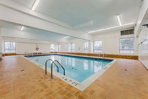 Mississauga apartment for rent - A large indoor swimming pool with tiled floors and walls.