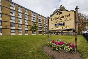 Brampton apartment for rent - A sign for Leslie Street Apartments stands in front of a brick building.
