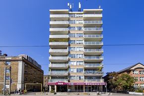 Toronto apartment for rent - A tall building with a green plant on the side and a sign that says Convenience.