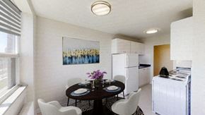 North York apartment for rent - A dining room with a table set for two and a painting on the wall.