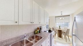 North York apartment for rent - A kitchen with white cabinets and a granite countertop.