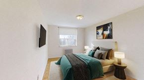 North York apartment for rent - A bedroom with a bed, a nightstand, and a television.