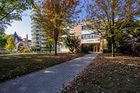 Toronto apartment for rent - A brick walkway leads to a building with a clock tower in the background.