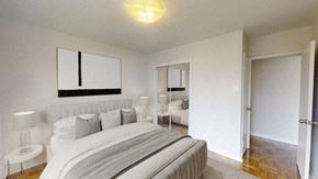 Toronto apartment for rent - A bedroom with a large bed and a mirror above it.