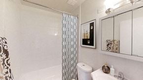 Toronto apartment for rent - A white toilet sits next to a bathtub in a bathroom.