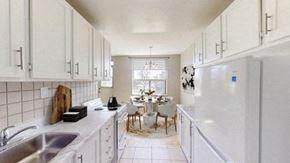 North York apartment for rent - A kitchen with white cabinets and a white fridge.