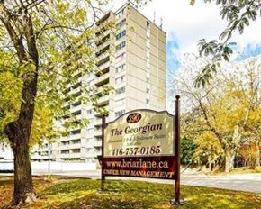 East York apartment for rent - A sign for The Georgian apartment building stands in front of a tall building.