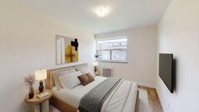 North York apartment for rent - A bedroom with a bed, nightstand, and a window.