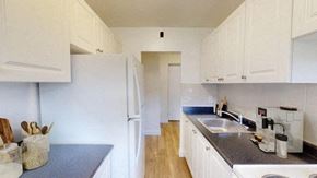 North York apartment for rent - A kitchen with white cabinets and a white refrigerator.