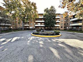 Toronto apartment for rent - A roundabout with a yellow border in the middle of a paved area with trees and buildings in the background.