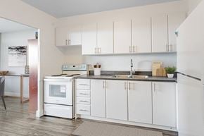 North York apartment for rent - A kitchen with white cabinets and a black countertop.