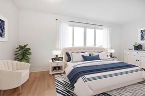 Richmond Hill apartment for rent - A bedroom with a large bed and a white chair.