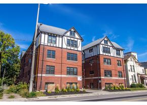 Kitchener apartment for rent - A red brick building with white trim and a black roof.