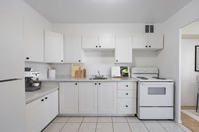 Mississauga apartment for rent - A white kitchen with a stove, oven, and cabinets.