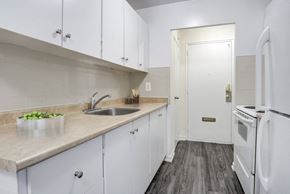 Brampton apartment for rent - A kitchen with white cabinets and a wooden floor.