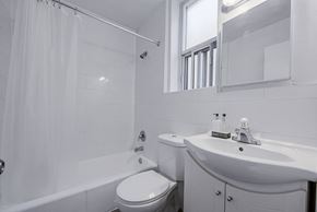 Toronto apartment for rent - A white bathroom with a toilet, sink, and bathtub.
