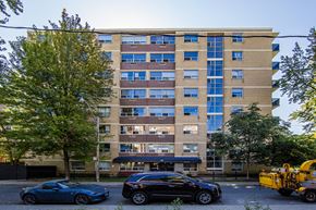 Toronto apartment for rent - A large building with a lot of windows and cars parked in front.