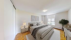 Thornhill apartment for rent - A bedroom with a large bed and a small nightstand with a lamp.
