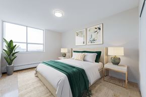 North York apartment for rent - A bedroom with a large bed and a green blanket.