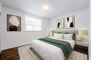 Toronto apartment for rent - A bedroom with a bed, two lamps, and two pictures on the wall.