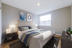 North York apartment for rent - A bedroom with a large bed and a nightstand with a lamp.