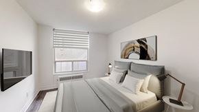Toronto apartment for rent - A bedroom with a large bed and a painting on the wall.