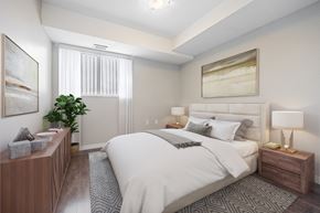 London apartment for rent - A well-lit bedroom with a large bed and a wooden nightstand.