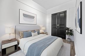 Kitchener apartment for rent - A bedroom with a large bed and a painting on the wall.