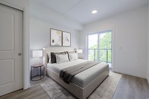 Waterloo apartment for rent - A bedroom with a bed, a lamp, and a painting on the wall.