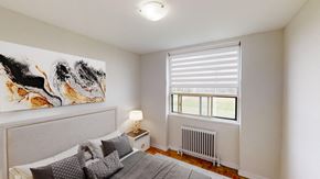 Brampton apartment for rent - A bedroom with a large painting on the wall and a bed with pillows.