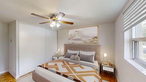 Orangeville apartment for rent - A bedroom with a large bed and a ceiling fan.