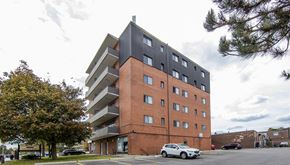 Brampton apartment for rent - A modern apartment building with a white car parked in front.