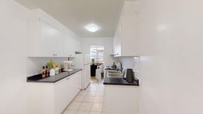 Thornhill apartment for rent - A kitchen with white cabinets and a black countertop.