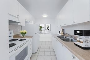 North York apartment for rent - A white kitchen with a black stove top and a black microwave.