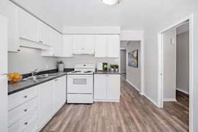 London townhouse for rent - A kitchen with white cabinets and a wooden floor.