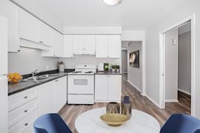 London townhouse for rent - A modern kitchen with white cabinets and a wooden table.