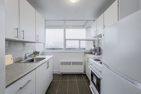 North York apartment for rent - A modern kitchen with white appliances and cabinets.