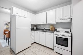 London apartment for rent - A white kitchen with a refrigerator, stove, and cabinets.