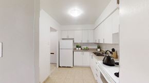 Mississauga apartment for rent - A kitchen with white appliances and cabinets.