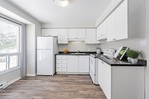London townhouse for rent - A kitchen with white cabinets and a black countertop.