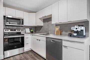 Waterloo apartment for rent - A modern kitchen with white cabinets and stainless steel appliances.