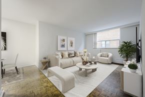 Toronto apartment for rent - A living room with a white couch, a coffee table, and a television.