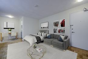 Toronto apartment for rent - A bedroom with a bed, couch, and pictures on the wall.