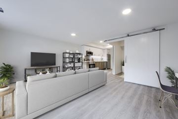 Waterloo apartment for rent - A modern living room with a white couch and a television on the wall.