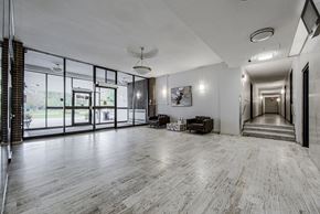 Thornhill apartment for rent - A spacious room with wooden flooring and a staircase leading to another room.