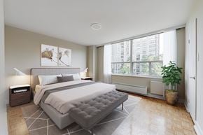 Toronto apartment for rent - A bedroom with a large bed and a plant.