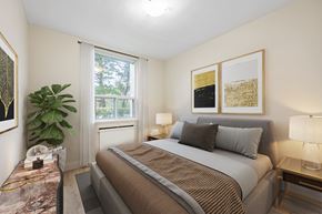 North York apartment for rent - A bedroom with a large bed and a plant on the side table.