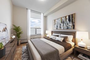 North York apartment for rent - A well-lit bedroom with a large bed and a painting on the wall.
