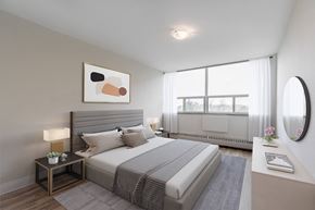 North York apartment for rent - A bedroom with a large bed, a nightstand with a lamp, and a painting on the wall.