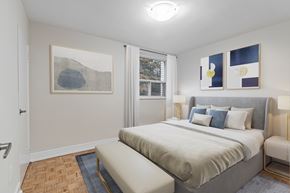 North York apartment for rent - A bedroom with a large bed and a painting on the wall.